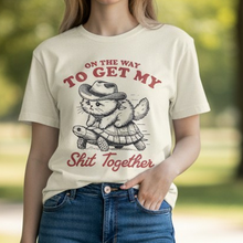 Load image into Gallery viewer, **On the Way to Get My Shit Together Cat Riding Turtle Graphic Tee – Natural Unisex Shirt (S–2XL)**