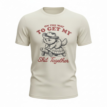 Load image into Gallery viewer, **On the Way to Get My Shit Together Cat Riding Turtle Graphic Tee – Natural Unisex Shirt (S–2XL)**

